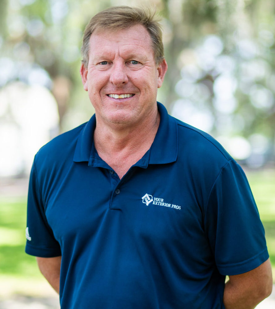 Professional man in blue Your Exterior Pros polo shirt smiling outdoors